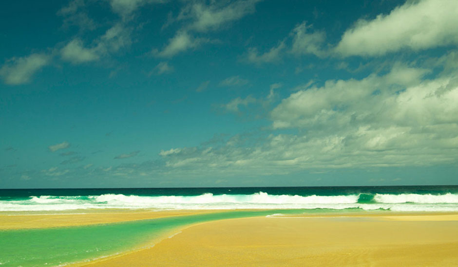 onde che si infrangono sulla spiaggia e cielo con effetto color verde ht