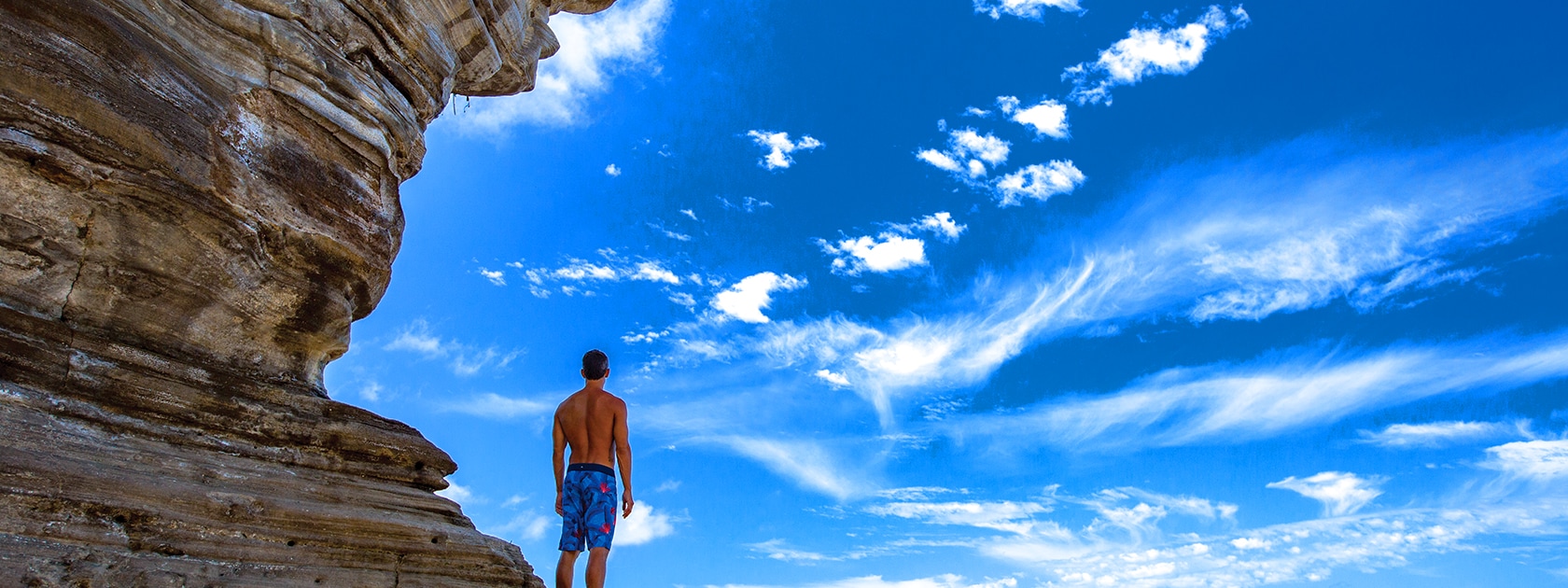 Man standing on side of cliff