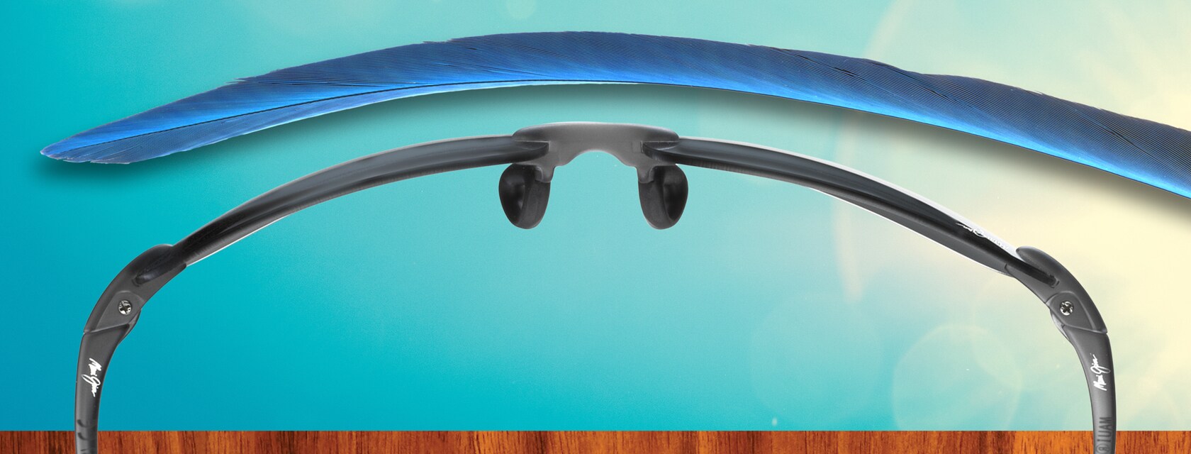 Maui Pure sunglasses next to feather.
