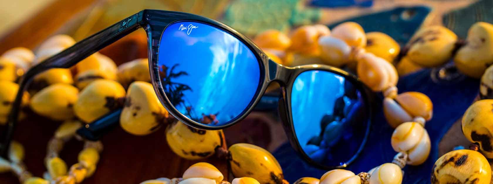 blue lens sunglasses displayed over seashell necklaces