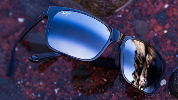 occhiali da sole appoggiati su rocce rosse che mostrano il rivestimento a doppio gradiente sulle lenti