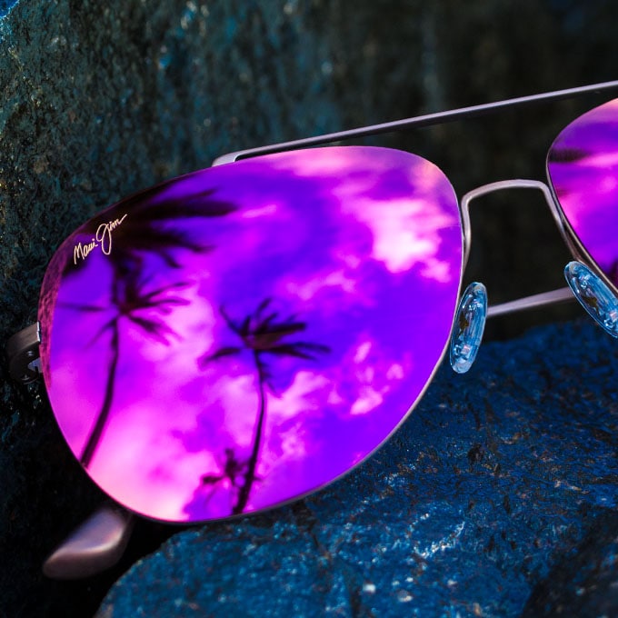 Sonnenbrille mit Drahtfassung und roséfarbenen Gläsern auf nassem Felsen