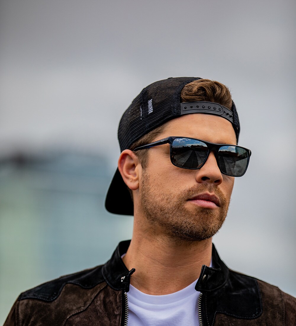 man wearing backwards hat and jacket and sunglasses
