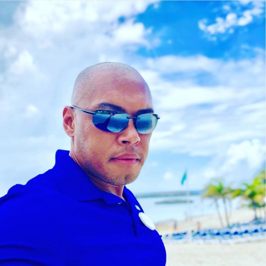 Mann am Strand, der neutrale graue Ho'okipa Sonnenbrille trägt