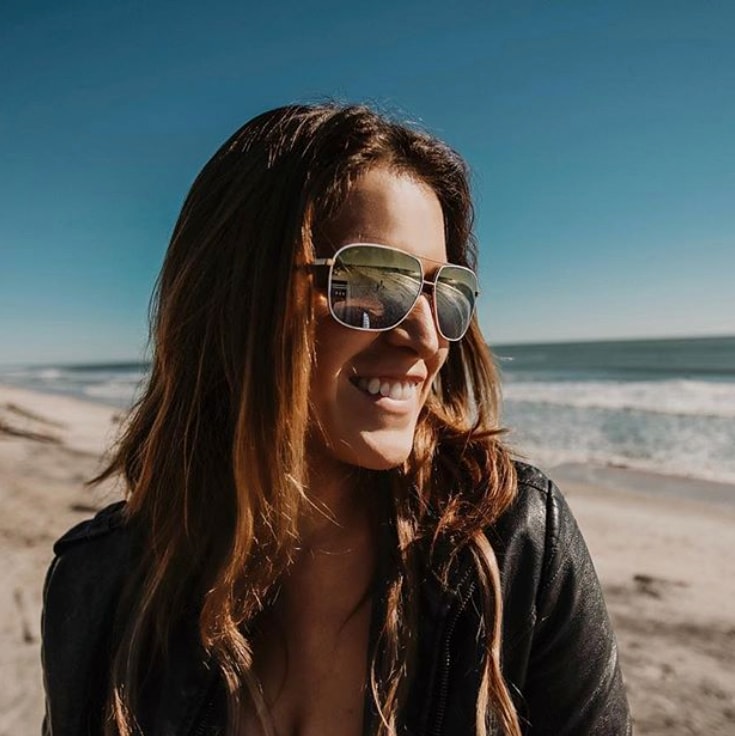 Woman at beach wearing Kami sunglasses with Gold to Silver Dual Mirror