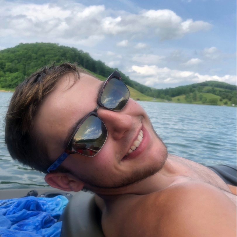 Mann im Boot, das braune klassische Sonnenbrille trägt