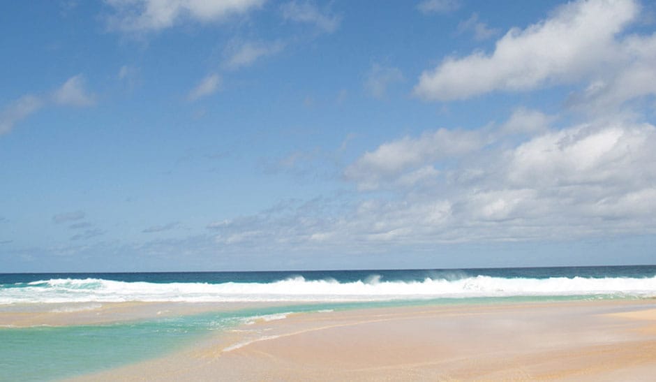 Vista de la playa de las olas y el cielo sin Maui Jim Lens