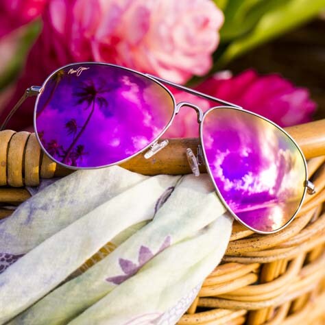 lentes de sol aviadores con cristales rosados exhibidos sobre canasto tejido