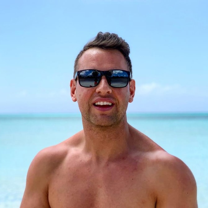Uomo in spiaggia indossando occhiali da sole Black Sands rossi